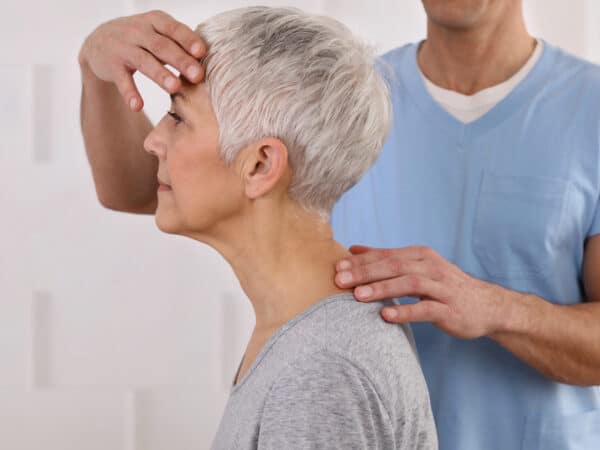 vârstnica cu spatele curbat, reprezentând cifoza senilă